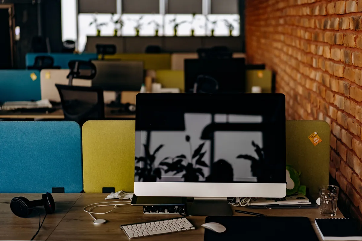Empty office desk with a desktop computer, keyboard, and mouse in a bright modern workspace